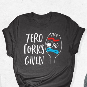 May include: A dark gray t-shirt with a white graphic of a fork with a face and the text "Zero Forks Given".