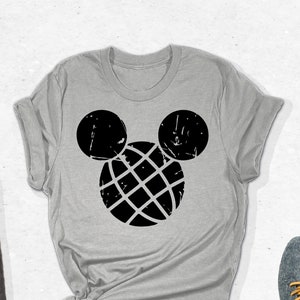 May include: A gray t-shirt with a black distressed Mickey Mouse head graphic. The graphic features a black circle with a grid pattern inside. The shirt is folded and laid flat on a white surface. The text "SPECTRUM APPAREL" is in the upper right corner of the image.