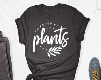 Camiseta "Powered By Plants", vegana, con temática de plantas, natural, sin crueldad animal, vegetariana, regalo herbívoro, amante de las plantas