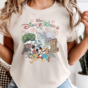 A woman wearing a white t-shirt with a Disney World graphic and text, smiling and posing with her hands behind her back.