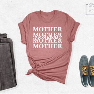 Puede incluir: Una camiseta rosa polvorienta con el texto "MOTHER MOTHER mama MOTHER MOTHER" en blanco.
