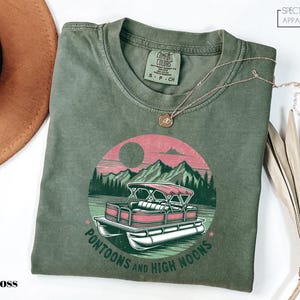 a green t - shirt with a pink car on it