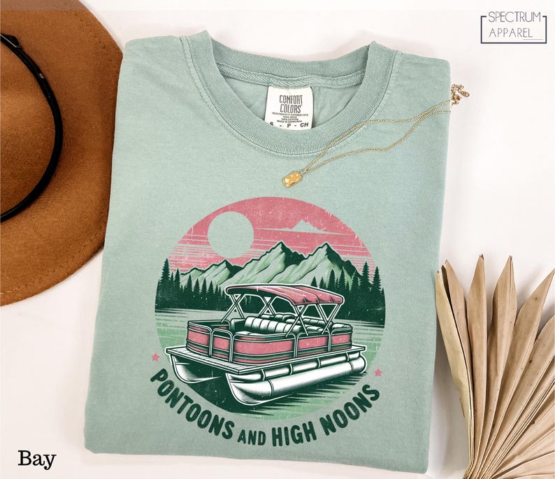 a t - shirt with a boat and mountains on it
