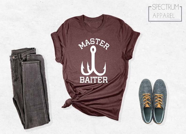 Pode incluir: Uma camiseta marrom com um gr&aacute;fico branco de um anzol de pesca e o texto "Master Baiter".