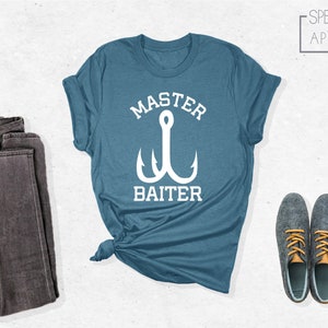 Pode incluir: Uma camiseta azul turquesa com um gr&aacute;fico branco de um anzol de pesca e o texto "Master Baiter".