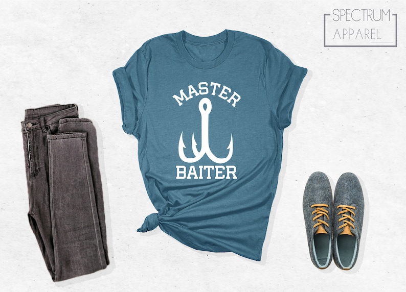 Pode incluir: Uma camiseta azul turquesa com um gr&aacute;fico branco de um anzol de pesca e o texto "Master Baiter".