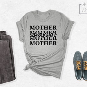 Puede incluir: Una camiseta gris jaspeada con el texto "MOTHER MOTHER mama MOTHER" en letras negras.