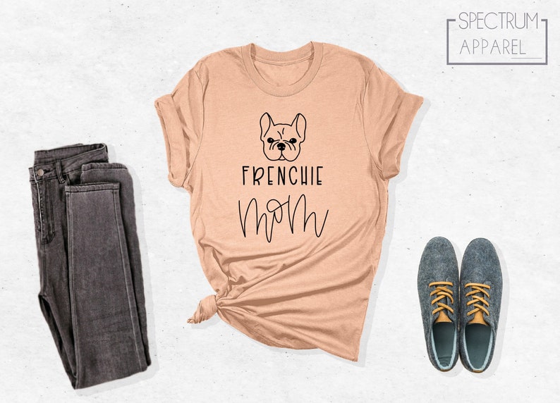 K&ouml;nnte beinhalten: Ein helles, pfirsichfarbenes T-Shirt mit einer schwarzen Umrandung eines franz&ouml;sischen Bulldoggen und dem Text "Frenchie Mom".