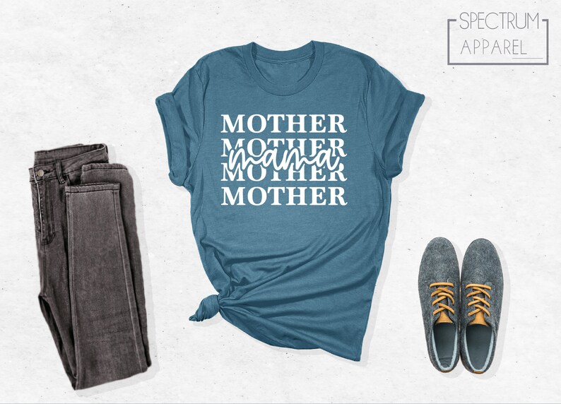 Puede incluir: Una camiseta azul turquesa con el texto "MOTHER MOTHER mama MOTHER" en letras blancas.