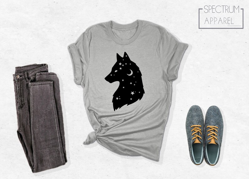 May include: A gray t-shirt with a black silhouette of a wolf's head with stars and a crescent moon inside. The text "SPECTRUM APPAREL" is in the top right corner of the image.