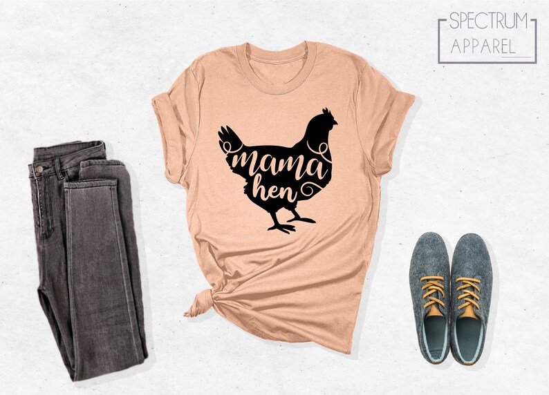 May include: A peach-colored t-shirt with a black silhouette of a chicken and the text "mama hen" in a stylized font.