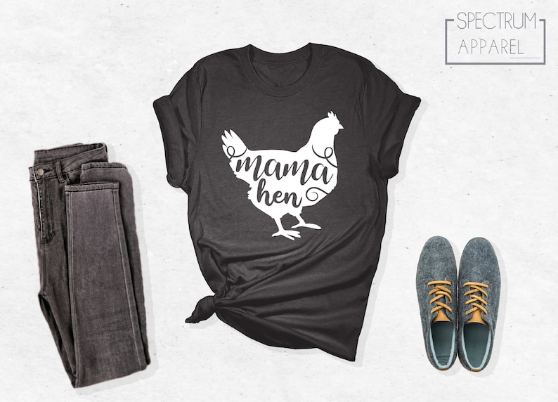 May include: A dark gray t-shirt with a white silhouette of a chicken and the text "mama hen" in a cursive font.