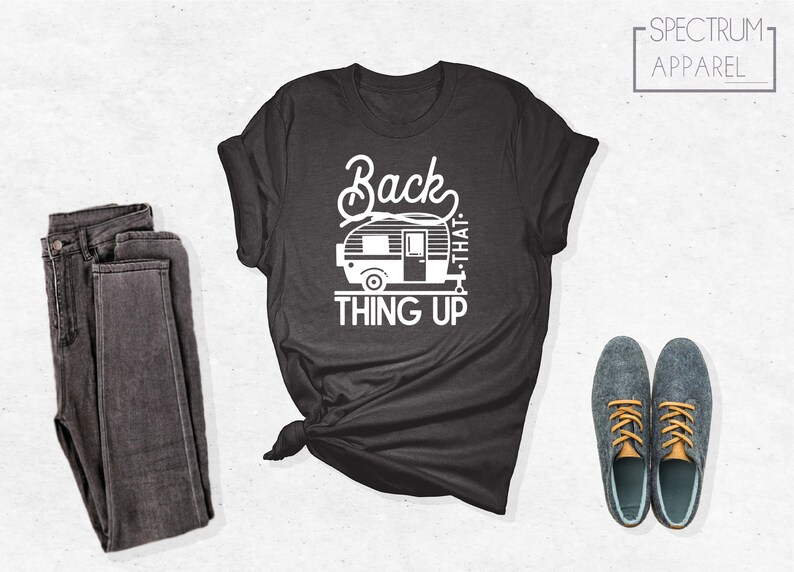 Może przedstawiać: Szary t-shirt z białym nadrukiem przedstawiającym przyczepę kempingową i tekstem "Back that thing up".