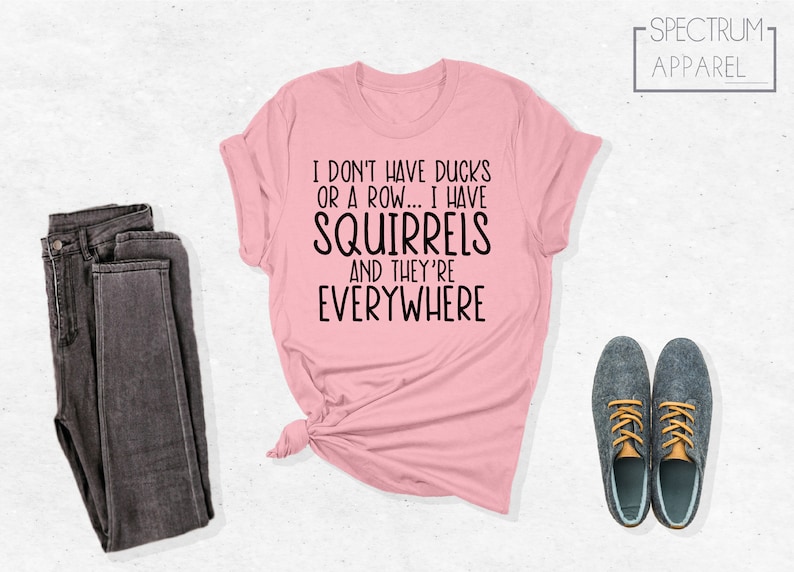 May include: A pink t-shirt with the text "I don't have ducks or a row... I have squirrels and they're everywhere".
