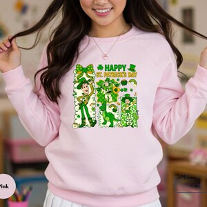 A woman wearing a pink sweatshirt with a cartoon character and text printed on it.