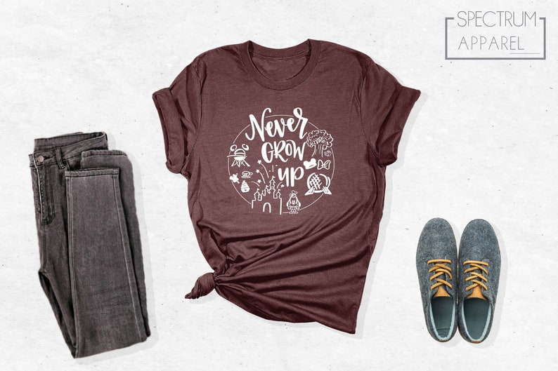 May include: A maroon t-shirt with a white graphic that says "Never Grow Up" and features various Disney icons.