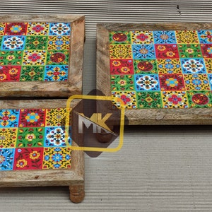 May include: Three wooden square coasters with colorful tile designs. The coasters are different sizes and have a rustic wood finish.