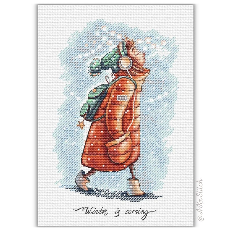 Peut inclure: Un motif de point de croix repr&eacute;sentant une personne portant un manteau d'hiver rouge, un chapeau vert et des &eacute;couteurs, marchant dans la neige. Le texte "Winter is coming" est &eacute;crit sous la personne.