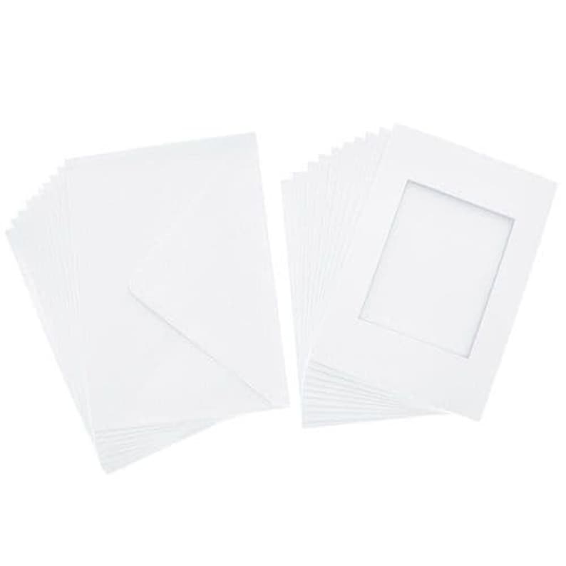 May include: A stack of white cardstock paper with a stack of white photo mats with a window opening.
