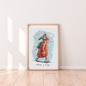 Peut inclure: Un motif de point de croix repr&eacute;sentant une personne portant un manteau d'hiver rouge et marron, un chapeau vert et des &eacute;couteurs, marchant dans la neige. Le texte "Winter is coming" est &eacute;crit sous la personne. Le motif est encadr&eacute; dans un cadre en bois clair.