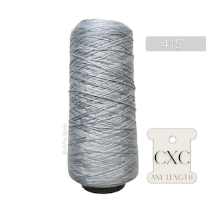 May include: A spool of silver grey thread with the text "CXC ANY LENGTH" on a white tag. The spool is labelled with the number "415".