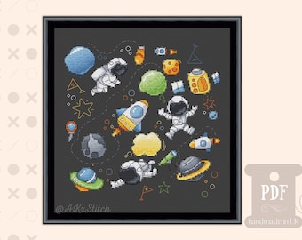 Puede incluir: Un patrón de punto de cruz con fondo negro y coloridas ilustraciones con temática espacial, incluyendo astronautas, cohetes, planetas y estrellas. El patrón está titulado "@AKx Stitch" en la esquina inferior izquierda.