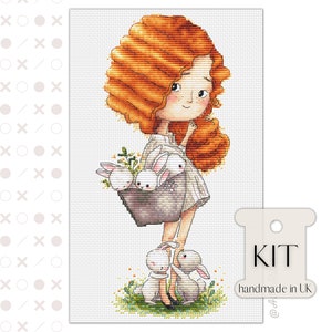 Puede incluir: Kit de punto de cruz con una niña de pelo rojo largo que sostiene una cesta de conejos blancos. La niña lleva un vestido blanco y zapatos negros. Hay dos conejos blancos más a sus pies. El kit está hecho a mano en el Reino Unido.