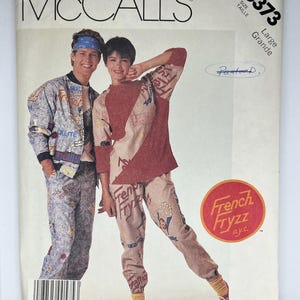 May include: McCall's sewing pattern featuring two people modeling matching outfits. The outfits include a jacket and pants with a blue and white design, and a red and tan top and pants set. The pattern is size Large.