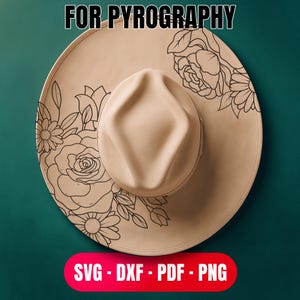May include: A beige fedora-style hat with a wide brim, featuring a floral design for pyrography. The hat has a central crease and a rounded crown. The brim is decorated with black line art of roses and daisies. Text at the top reads "FOR PYROGRAPHY".