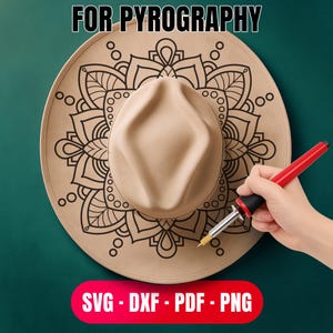 Op de afbeelding: Een beige fedora hoed met een zwart mandala ontwerp wordt getoond. De hoed wordt bewerkt met een pyrografie tool. De tekst "FOR PYROGRAPHY" staat bovenaan en "SVG - DXF - PDF - PNG" onderaan.