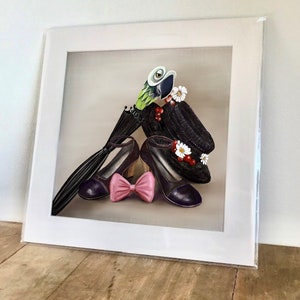 May include: A framed illustration of a black hat with a green parrot perched on top, two purple shoes with a pink bow, and a black umbrella. The hat is decorated with white flowers and red berries.