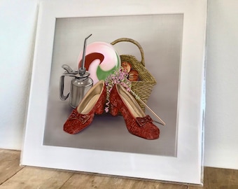 May include: A framed illustration of a still life featuring a pair of red ruby slippers, a vintage oil can, a pink and green swirl lollipop, and a wicker basket filled with apples.