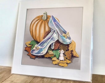 May include: A framed illustration of a glass slipper, a pumpkin, and a small mouse on a bed of autumn leaves. The glass slipper is iridescent and has a butterfly detail. The pumpkin is orange and the mouse is white.
