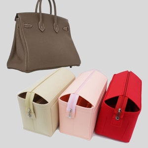 Op de afbeelding: Drie feltaschenorganizers in beige, roze en rood. De organizers hebben een ritssluiting en zijn ontworpen om in een grotere handtas te passen.