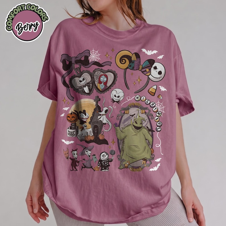 May include: Mauve t-shirt featuring a colorful graphic design with characters and elements from "The Nightmare Before Christmas." The design includes Jack Skellington, Sally, Oogie Boogie, and other iconic imagery. The shirt has the text "Comfort Colors" and "Bery" in a circle.