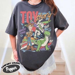 Puede incluir: Una taza de cer&aacute;mica blanca con un asa negra y el texto "But First, Coffee" en negrita negra. La taza est&aacute; llena de un l&iacute;quido oscuro, probablemente caf&eacute;, y se encuentra sobre una superficie clara.