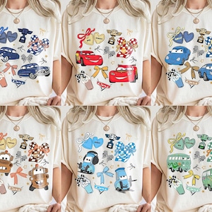 Puede incluir: Camisetas color crema con gr&aacute;ficos de coches de dibujos animados coloridos. Cada camiseta presenta diferentes dise&ntilde;os de coches, lazos, corazones e ilustraciones de trofeos. Las camisetas son adecuadas para ropa casual y est&aacute;n disponibles en varias tallas.