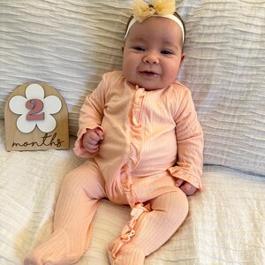 adorable baby with 2 month boho flower monthly milestone marker.