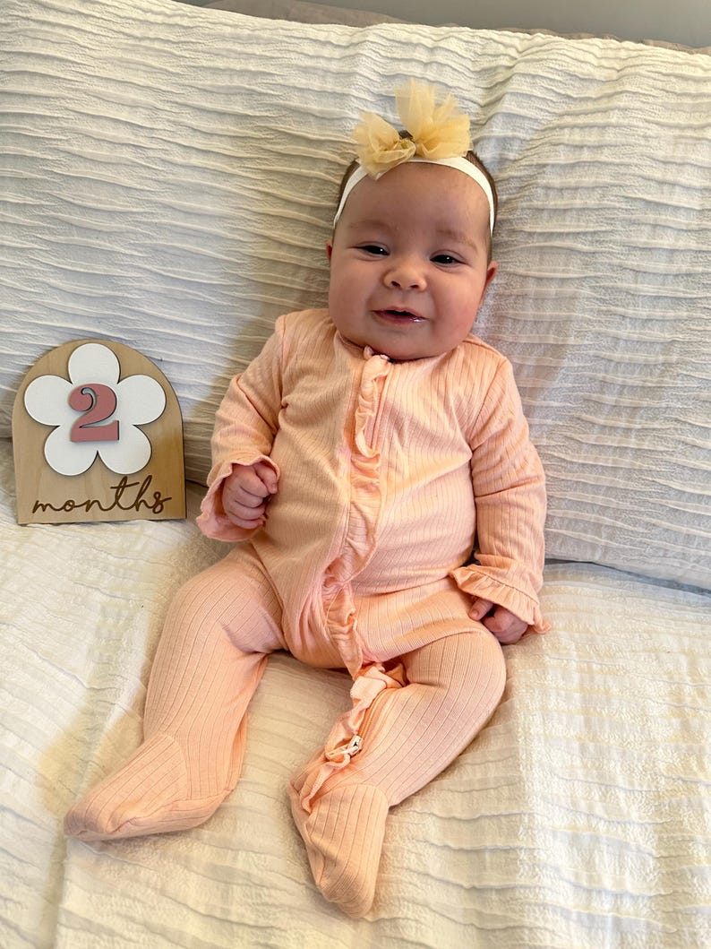 adorable baby with 2 month boho flower monthly milestone marker.