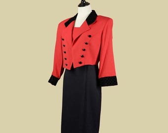 May include: A red cropped jacket with black velvet trim and black buttons, paired with a black skirt.