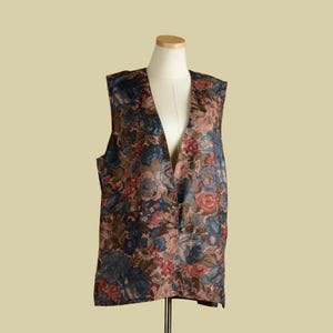 May include: A sleeveless vest with a floral pattern in shades of brown, blue, and red. The vest has a V-neck and a button closure.