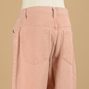 May include: A pair of light pink denim pants with a back pocket.
