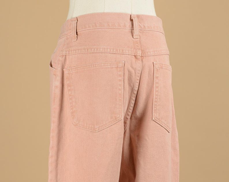 May include: A pair of light pink denim pants with a back pocket.