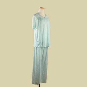May include: A light blue pajama set with short sleeves and a button-up top. The top has a delicate floral embroidery around the neckline.