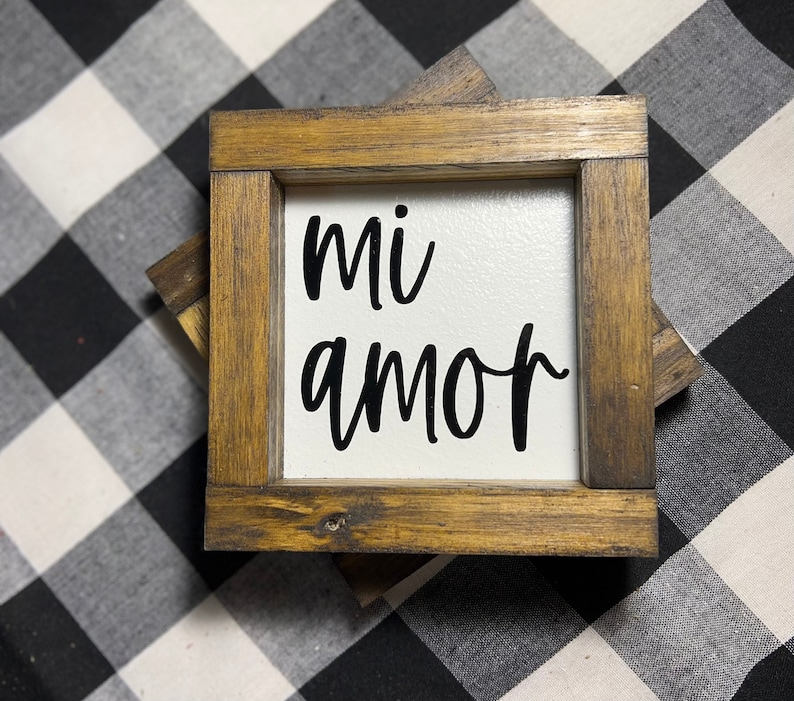 May include: A wooden framed sign with the words "mi amor" in black script on a white background.