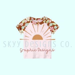 May include: A pink baby t-shirt with a brown floral print on the sleeves and a graphic of a sun with rays on the front. The text "sky designs co. Graphic Designs" is printed below the sun graphic.