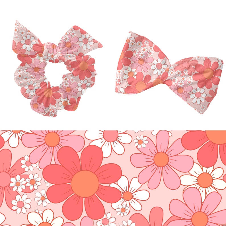 Op de afbeelding: Een roze en witte bloemenprint scrunchie en strik. De print heeft roze en witte madeliefjes op een lichtroze achtergrond.