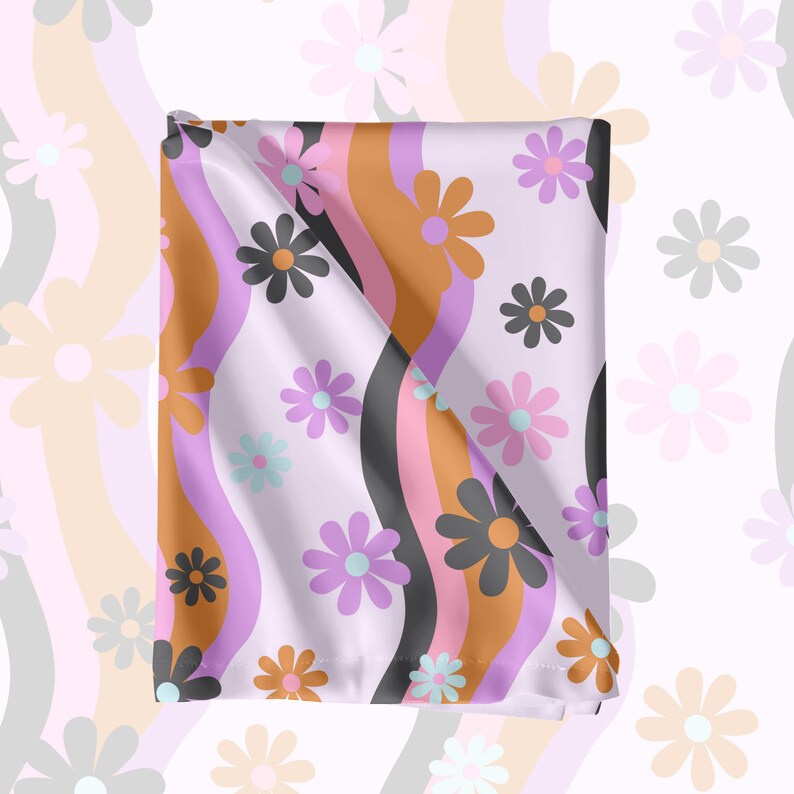 May include: A purple and white fabric with a repeating pattern of pink, orange, and black daisies on a wavy background.
