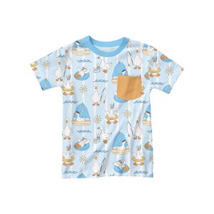 May include: A light blue t-shirt with a pattern of white geese engaged in various nautical activities. The geese are depicted sailing, fishing, and floating on inner tubes. The shirt has a light blue collar and a small, tan pocket.