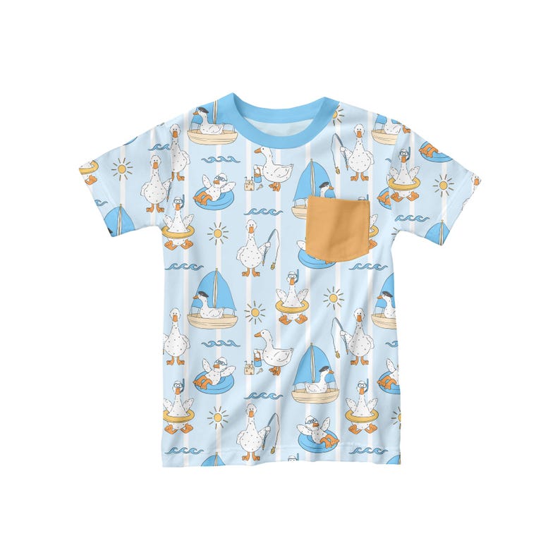May include: A light blue t-shirt with a pattern of white geese engaged in various nautical activities. The geese are depicted sailing, fishing, and floating on inner tubes. The shirt has a light blue collar and a small, tan pocket.